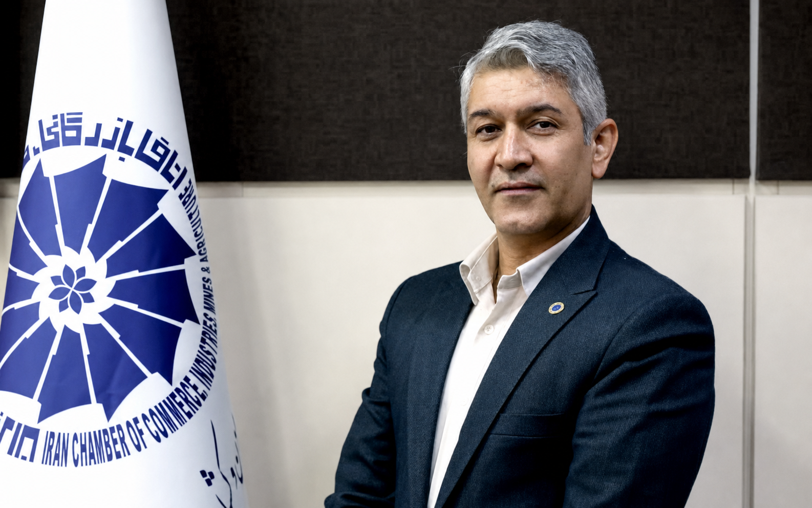 علیرضا خامه زر در کنار نشان اتاق بازرگانی ایران